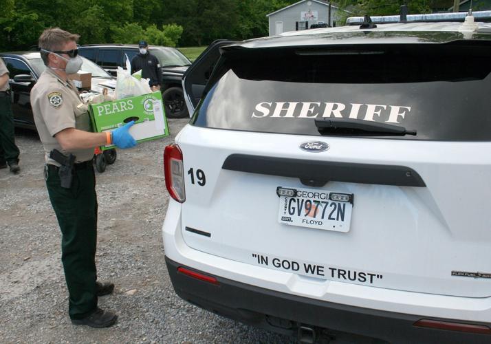 Harkins puts food in Sheriff's vehicle for delivery