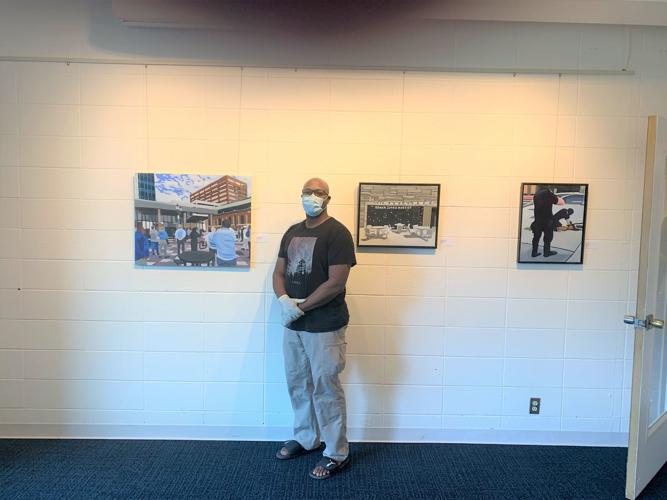 Courtland Blade in front of his paintings at the Harrison Center