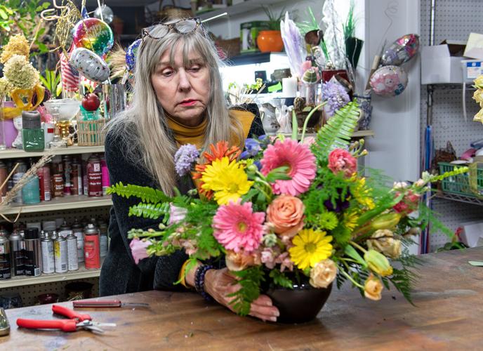 Florist carefully arranging colorful Valentine's Day bouquet in shop