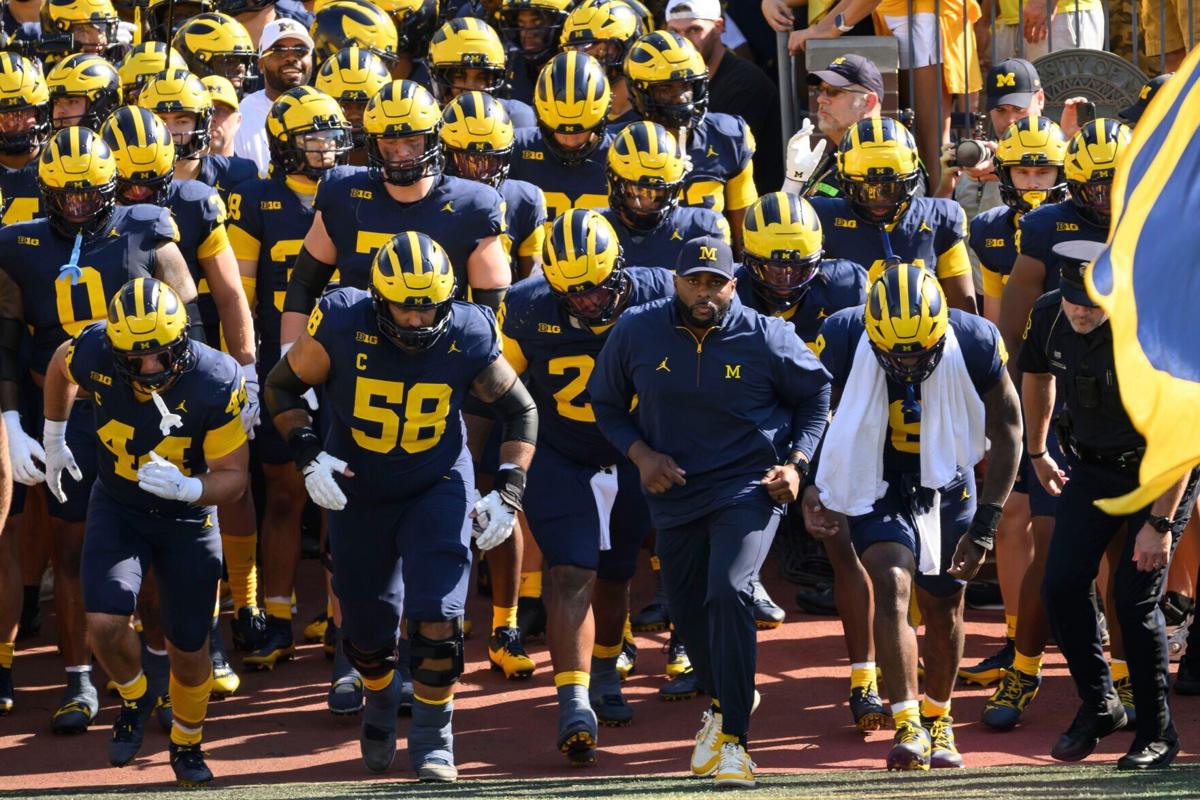Michigan head coach Sherrone Moore and the Wolverines run out of the tunnel for the start of a game against Wisconsin at Michigan Stadium on Oct. 4, 2025, in Ann Arbor, Michigan.