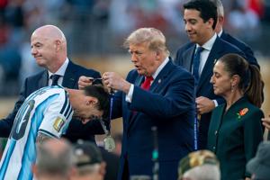 President Donald Trump places a medal on Argentina forward Lionel Messi (10) following Spain’s victory over Argentina during the