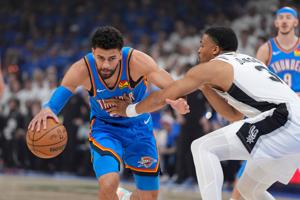 Oklahoma City Thunder guard Ajay Mitchell (25) dribbles beside San Antonio Spurs forward Keldon Johnson (3) during Game 2 of the Western Conference Finals between the Oklahoma City Thunder and the San Antonio Spurs at Paycom Center in Oklahoma City, 