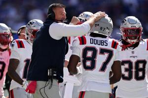 Head coach Mike Vrabel of the New England Patriots congratulates Romeo Doubs after a touchdown against the Buffalo Bills during the first quarter at Highmark Stadium on Sunday, Oct. 4, 2026, in Orchard Park, N.Y..