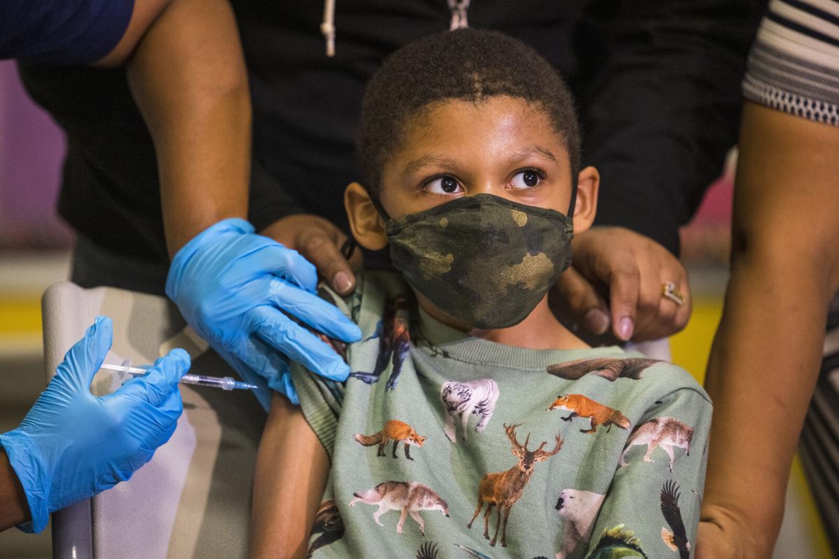 Christopher Reyes, 9, sits silently as he is administered the coronavirus vaccine at a vaccination pop-up site at P.S. 19 on Nov. 8, 2021 in the Lower East Side in New York City.