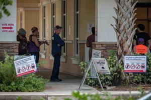 Voters stand in line to vote at the Acreage Branch of the Palm Beach County Library System during primary voting in