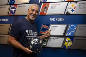 Villanova head football coach Mark Ferrante posed for a portrait with an all-star helmet worn by former fullback Ralph Pasquariello, who played in the 1950 Chicago Charities game, with the team that defeated the Eagles.