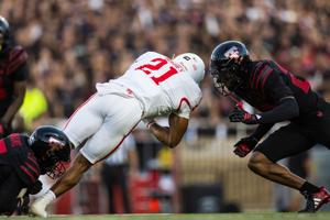 Texas Tech's Austin Romaine and Malik Esquerra combine to tackle Houston's Makhi Hughes during the first half at Galaxy Stadium on Friday, Sept. 18, 2026, in Lubbock, Texas.