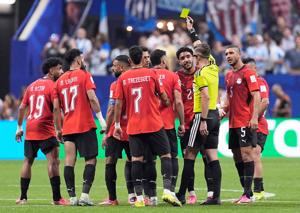 Egypt's Hamdy Fathy is shown a yellow card by referee Francois Letexier.