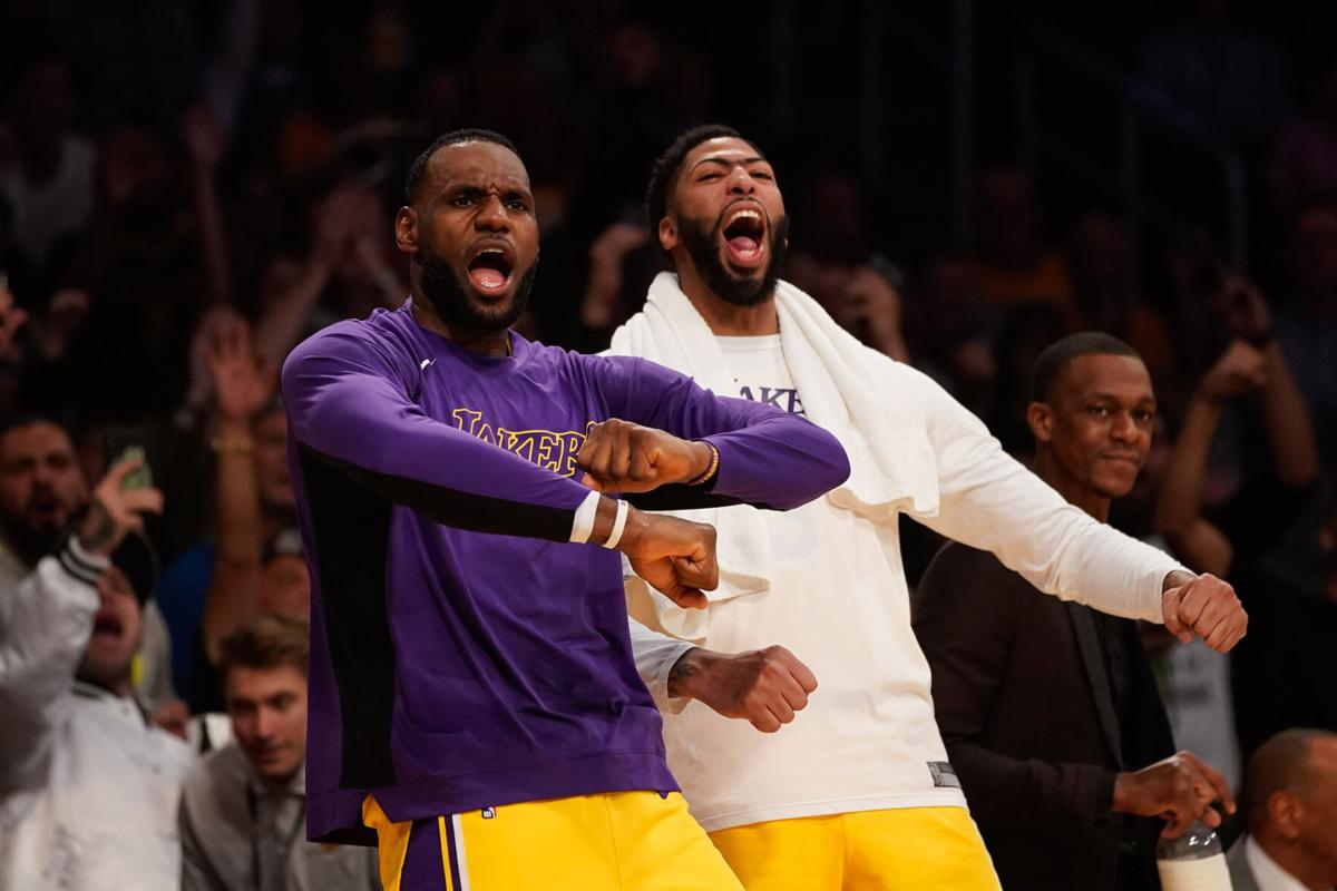 The Los Angeles Lakers' LeBron James, left, and Anthony Davis celebrate on the bench during an October 2019 game against the Memphis Grizzlies at Staples Center in Los Angeles.