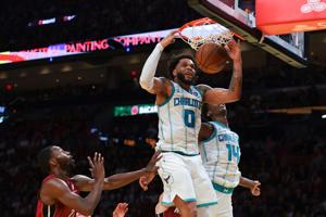 Charlotte Hornets forward Miles Bridges (0) dunks against Miami Heat forward Andrew Wiggins (22) during the second quarter at Kaseya Center in Miami, Florida.