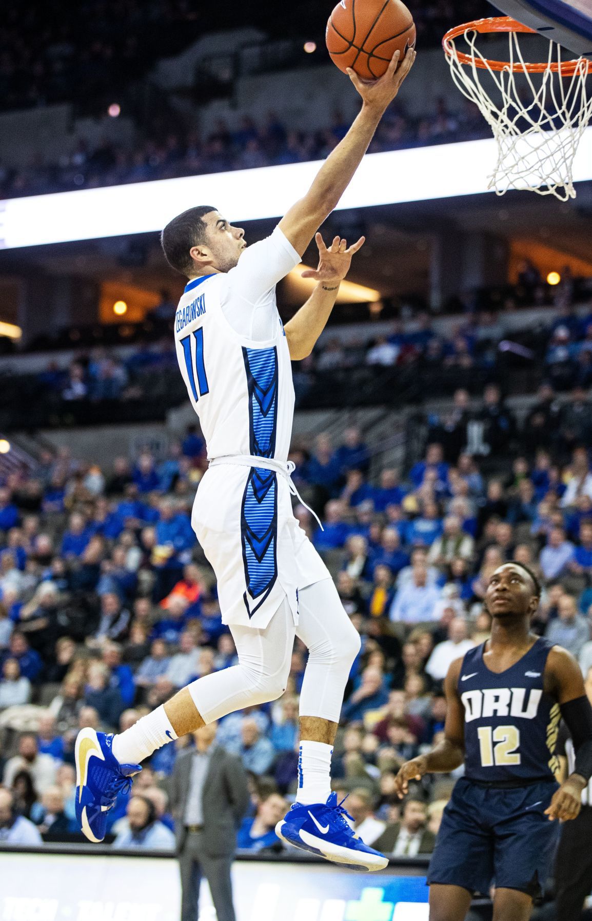 Former Creighton guard Mike Caruso watching his son Alex help