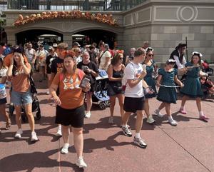Walt Disney World visitors, some in holiday costumes, work their way into Magic Kingdom theme park for early admittance to Mickey's Not-So-Scary Halloween Party, an after-hours event with exclusive offerings and shows.