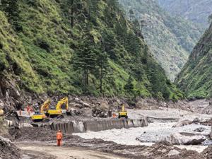 Rescue workers repair a damaged road leading to Gyirong Port following a mudslide, in Shigatse