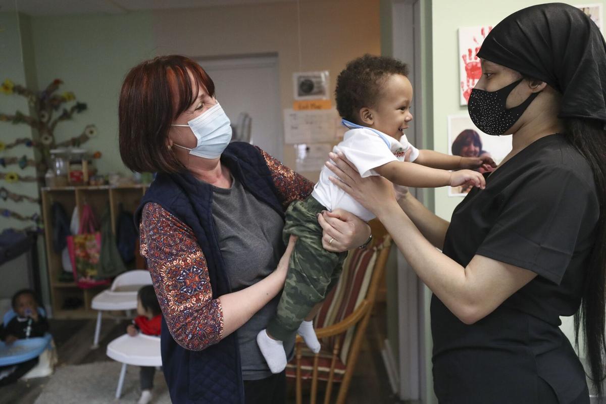 Teneema Tibbs, right, picks up her son, James, from his teacher, Mirjeta Teneqexhiu at the Little Learners Literacy Academy in South Philadelphia.