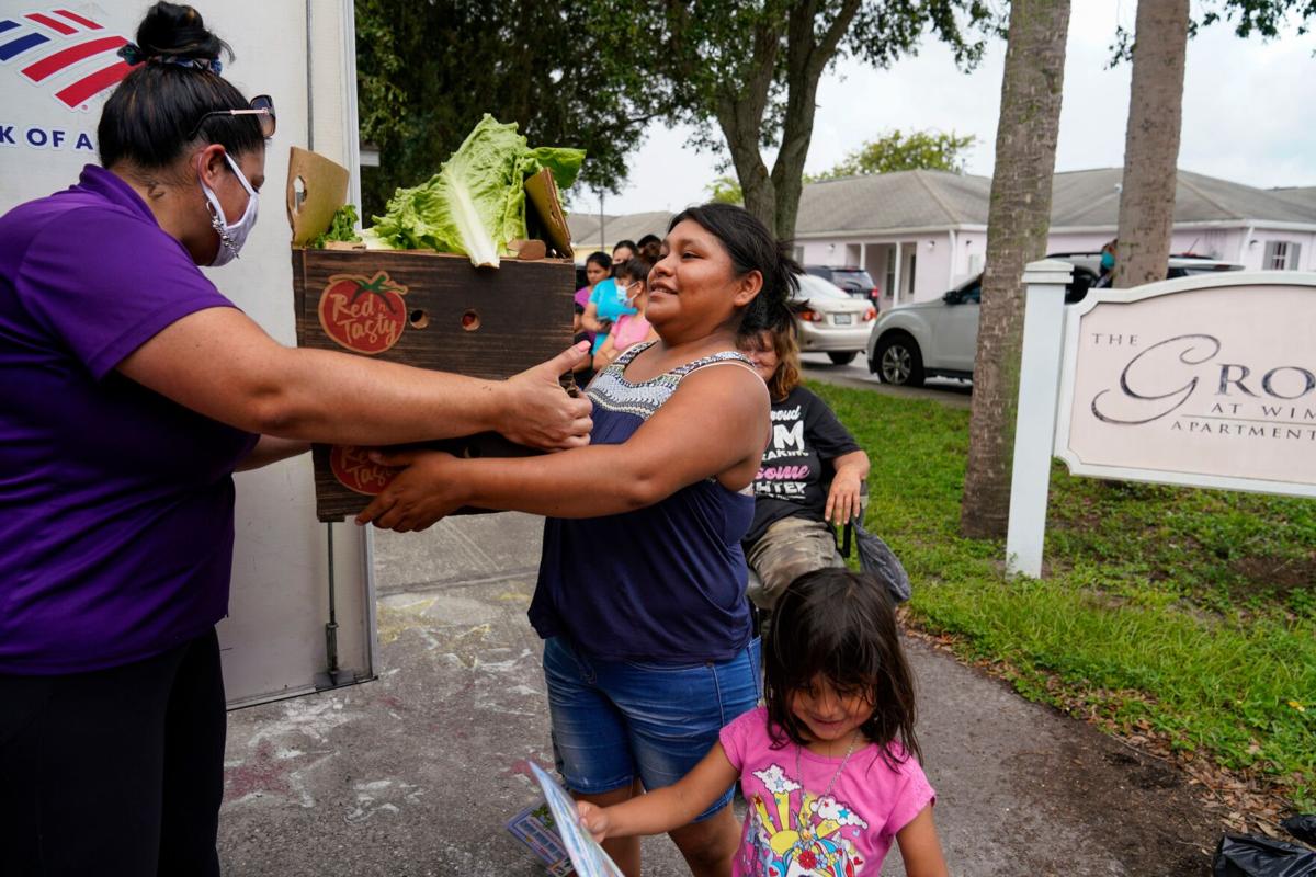 Lorena Sanchez, 23, from Guatemala, picks up fruits and vegetables Thursday, September 16, 2021 during a twice-monthly visit to Wimauma by the Veggie Van, a mobile marketplace operated by the Tampa Metropolitan Area YMCA.