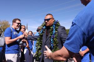 Brigham Young Cougars coach Kalani Sitake greets fan on the way in to LaVell Edwards Stadium before the game against the Arizona Wildcats.