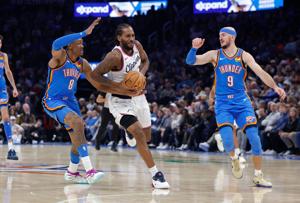 Dec 18, 2025; Oklahoma City, Oklahoma, USA; Los Angeles Clippers forward Kawhi Leonard (2) drives between Oklahoma City Thunder guard Jalen Williams (8) and guard Alex Caruso (9) during the second half at Paycom Center. Mandatory Credit: Alonzo Adams