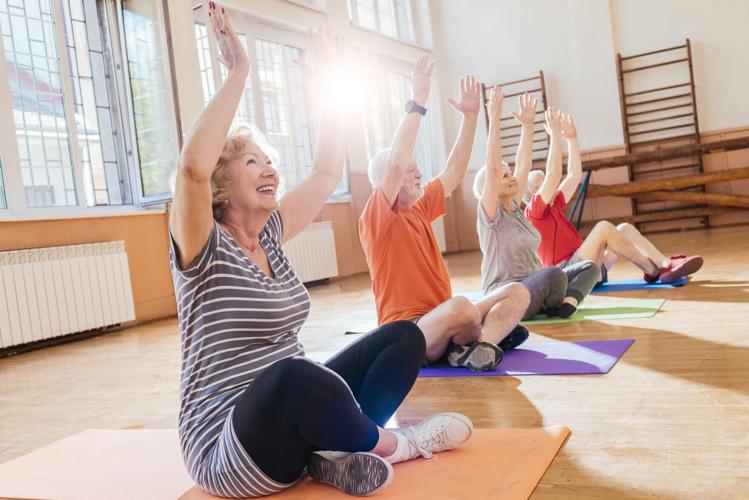 group of cheerful seniors doing yoga together