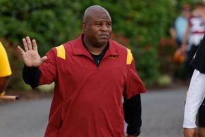 Eric Bieniemy, then the Washington Commanders offensive coordinator, waves to fans while walking to the fields prior to Day 2 of the Commanders 2023 training camp at OrthoVirginia Training Center in Ashburn, Virginia.