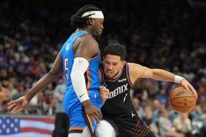 Apr 25, 2026; Phoenix, Arizona, USA; Phoenix Suns guard Devin Booker (1) drives on Oklahoma City Thunder guard Luguentz Dort (5) in the second half during game three of the first round of the 2026 NBA Playoffs at Mortgage Matchup Center. Mandatory Cr