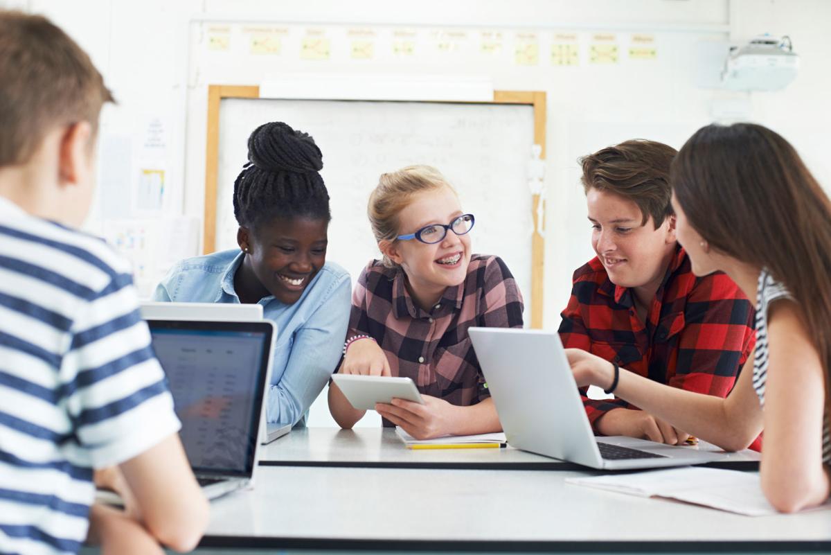 Group Of Teenage Students Collaborating On Project In IT Class