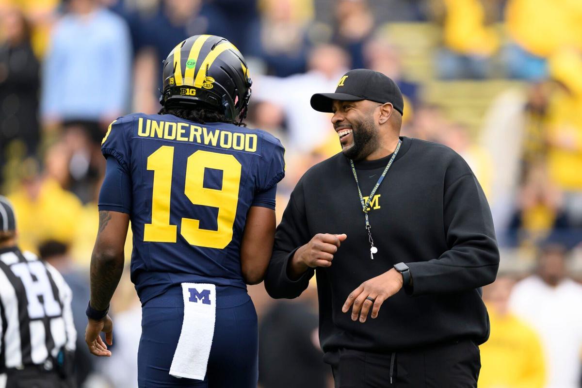 Michigan head coach Sherrone Moore, right, will have freshman quarterback Bryce Underwood in the mix this season, though the Wolverines say the competition at the position remains open.