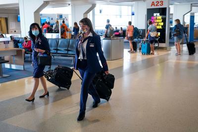 American Airlines flight attendants walk along the concourse at DFW International Airport.