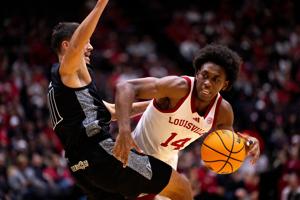 Cincinnati Bearcats guard Kerr Kriisa (11) fouls Louisville Cardinals guard Adrian Wooley (14) in the first half of the NCAA