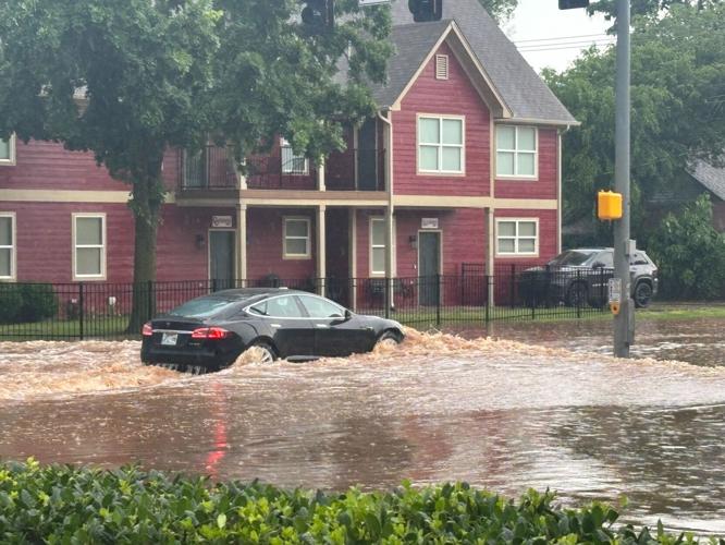Car drives through flooded Lindsey Street