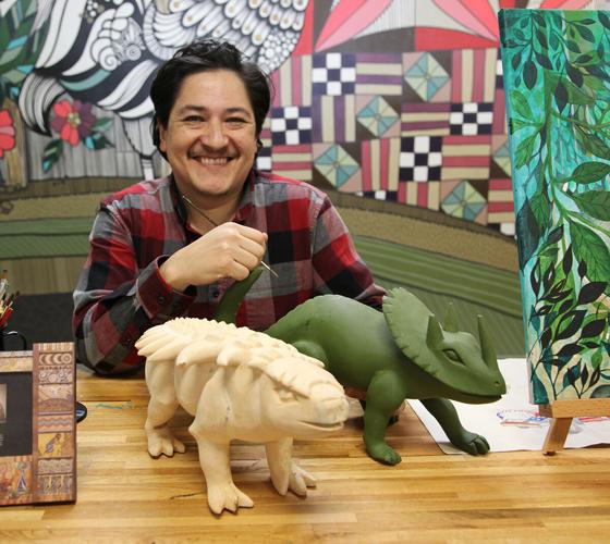 Oscar Nava Olano with dinosaurs awaiting painting