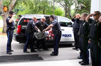 The back of a uniform Police Officer by a Police vehicle on the