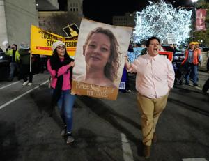 Ashton Goldsberry and Megan Wingfield carry a picture of Renee Good as they march south on Sixth Street. About 1,000 people showed up in downtown Louisville to protest the killing of Renee Nicole Good by ICE agents in Minneapolis on Jan. 8, 2026.