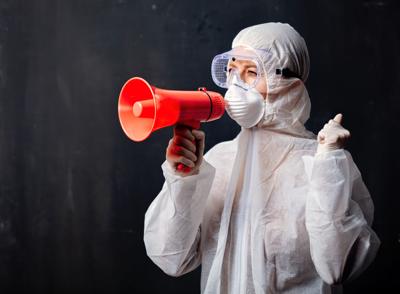 medic woman wearing protective clothing against the virus with megaphone