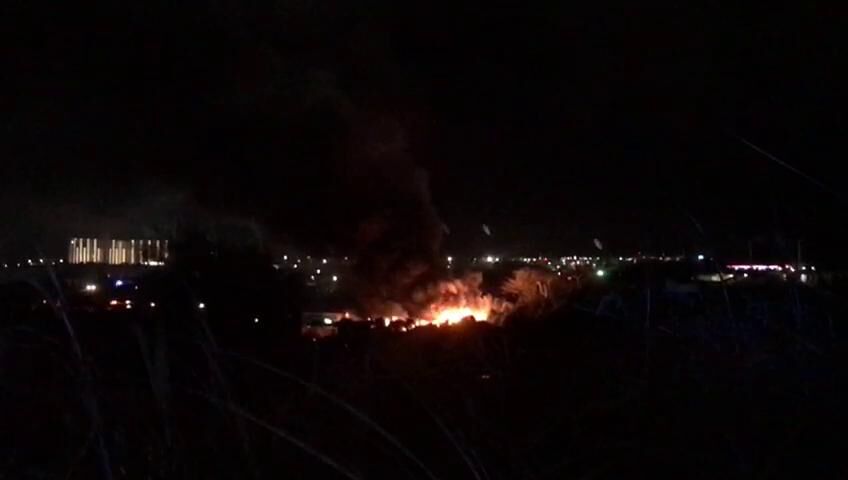 Firefighters battle blaze at auto shop and towing company yard