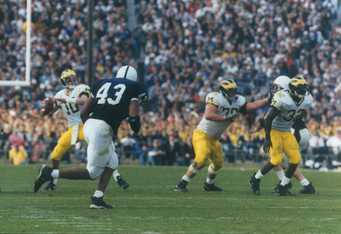 Michigan Wolverines quarterback Tom Brady (10) hands off the ball