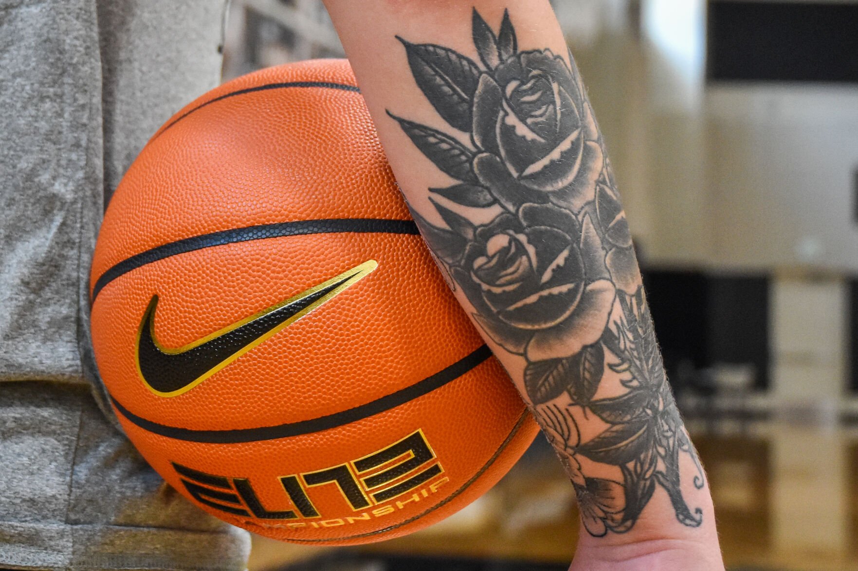with a basketball tattoo with wings on arm