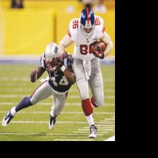 New York Giants wide receiver Victor Cruz, left, catches a touchdown pass  in front of New England Patriots strong safety James Ihedigbo during the  first quarter of Super Bowl XLVI February 5