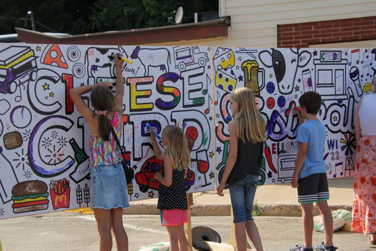 Young festival goers color a cheese curd poster