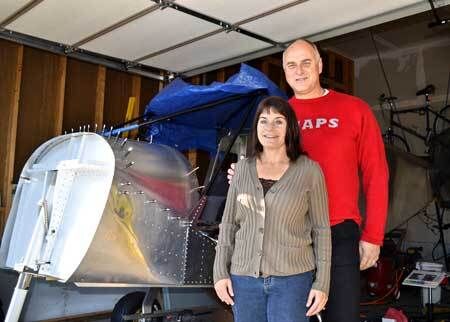 Joh and Christine Weigel in garage with airplane