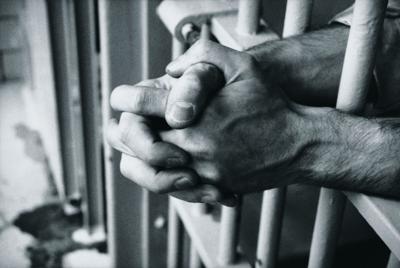 clasped hands, prison bars