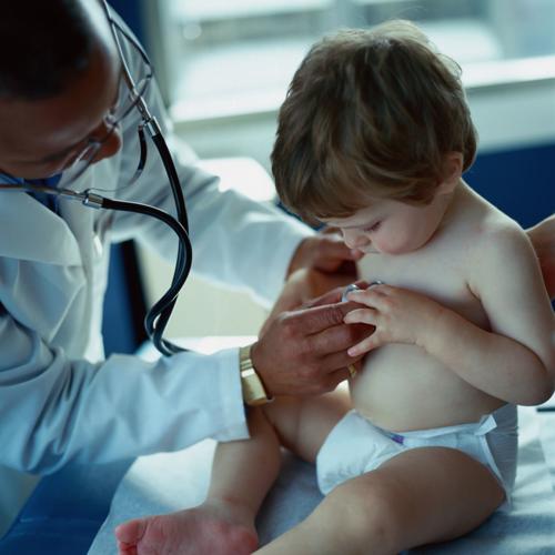 Doctor holding stethoscope to toddler's chest