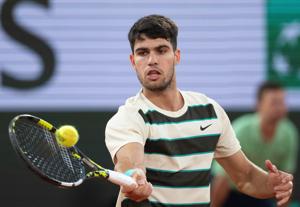 Carlos Alcaraz of Spain returns a shot during his match against Lorenzo Musetti of Italy during the 2025 French Open.