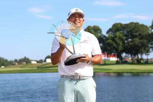 Kurt Kitayama celebrates with the trophy after winning the 2025 3M Open golf tournament in Blaine, Minnesota.