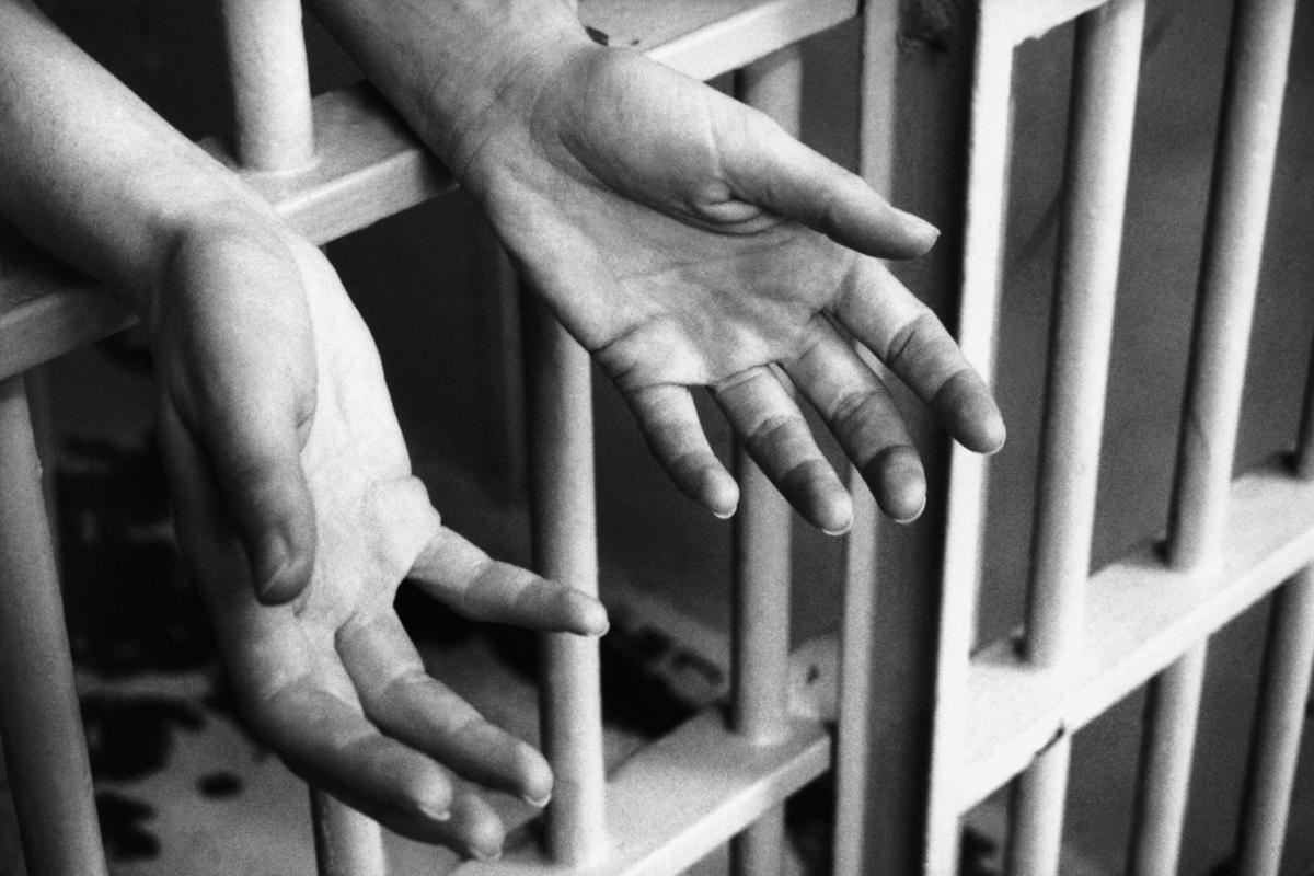 hands in prison cell
