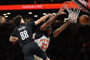 Mar 20, 2026; Brooklyn, New York, USA; New York Knicks center Mitchell Robinson (23) is fouled by Brooklyn Nets guard Nolan Traore (88) during the first half at Barclays Center. Mandatory Credit: Vincent Carchietta-Imagn Images