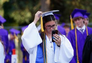 Shasta High School senior Mackenzie Barto fixes her tassel using her smartphone as a mirror. The Redding school held its 127th