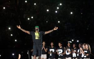 LeBron James acknowledges the crowd's reaction as he takes the stage for the I PROMISE Family Reunion event to welcome him home