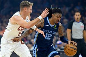 Nov 15, 2025; Cleveland, Ohio, USA; Cleveland Cavaliers guard Sam Merrill (5) defends Memphis Grizzlies guard Ja Morant (12) in the first quarter at Rocket Arena. Mandatory Credit: David Richard-Imagn Images
