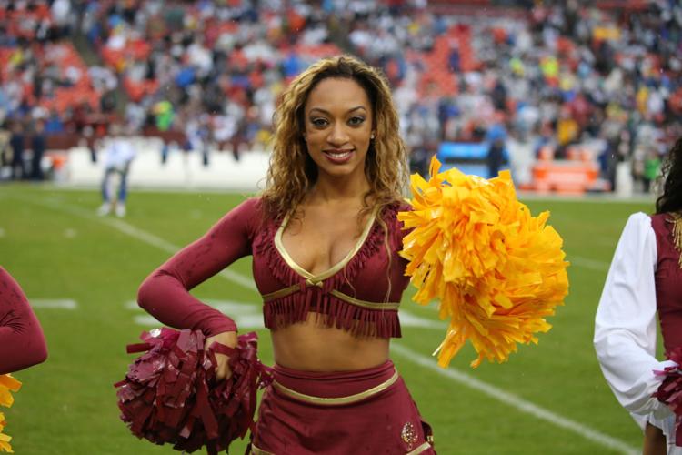 An Arizona Cardinals' cheerleader performs a high kick during the