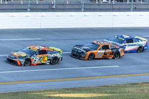Oct 19, 2025; Talladega, Alabama, USA; NASCAR Cup Series driver Chase Briscoe (19) takes a lead late past NASCAR Cup Series driver Chris Buescher (17) and NASCAR Cup Series driver Kyle Larson (5) during stage three of the YellaWood 500 at Talladega S